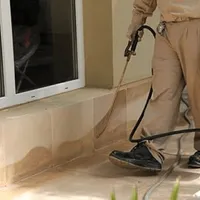 General pest control technician spraying exterior perimeter around a home in Richmond, VA