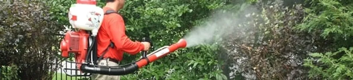 Mosquito control technician fogging shrubs and landscaping for mosquito treatment in Richmond, VA