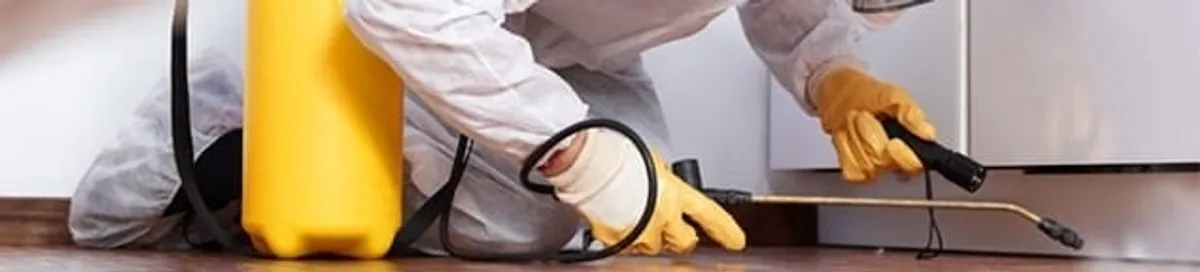 Roach exterminator treating cracks and crevices along kitchen baseboards in Richmond, VA